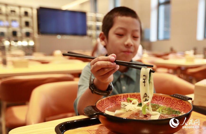 殷墟博物館推出的甲骨文面深受游客喜愛。人民網(wǎng)記者 慎志遠(yuǎn) 攝