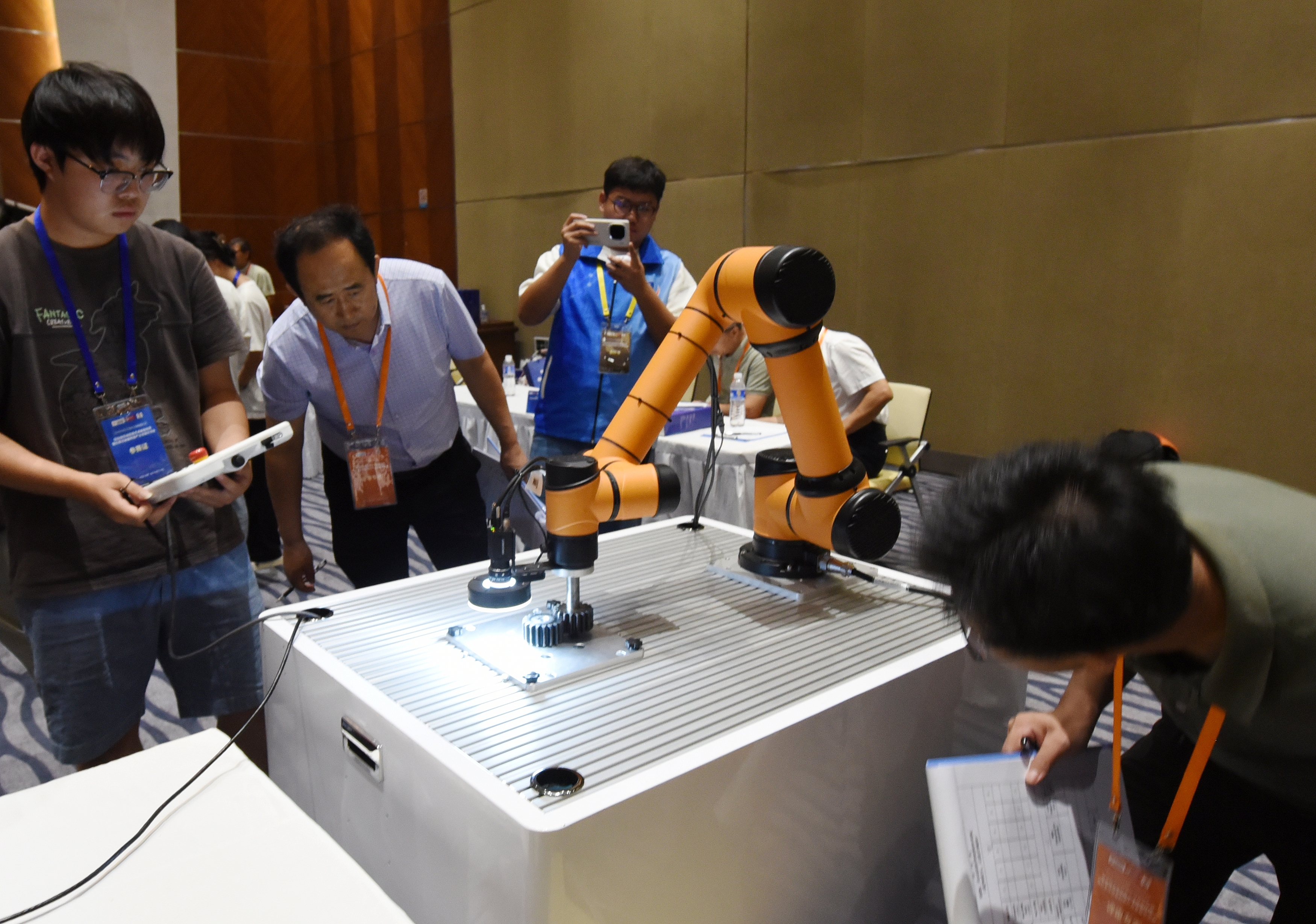 2025年中國(guó)大學(xué)生機(jī)械工程創(chuàng)新創(chuàng)意大賽智能精密裝配賽京津冀魯聯(lián)賽現(xiàn)場(chǎng)，評(píng)委對(duì)參賽選手進(jìn)行實(shí)操調(diào)試評(píng)比。